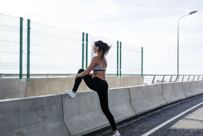 Woman exercising on bridge