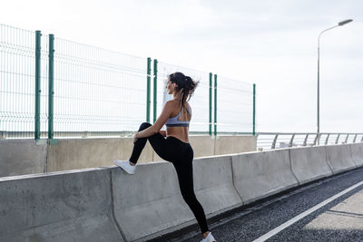 Full length of woman running on bridge over river against sky