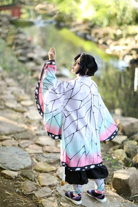 Rear view of woman standing on footpath