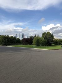 Road by buildings against sky in city