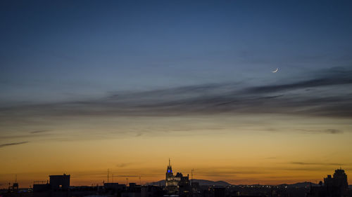 Silhouette cityscape against sky during sunset