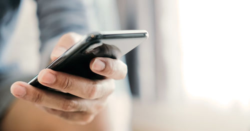 Midsection of man using mobile phone