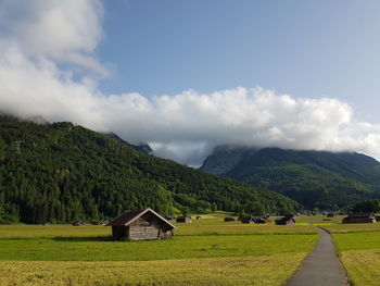 Scenic view of green landscape and mountains against sky