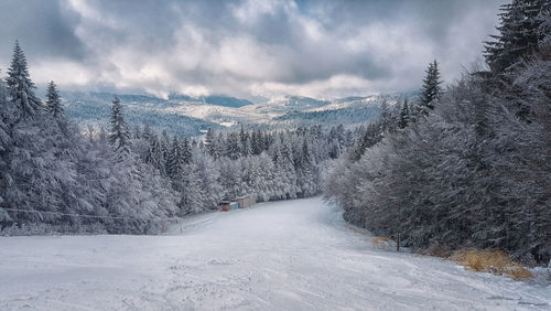 Snow covered land against sky