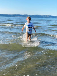 Full length of boy enjoying in sea