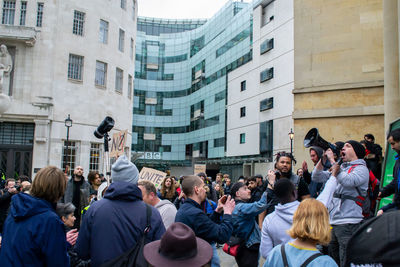 People standing on street amidst buildings in city