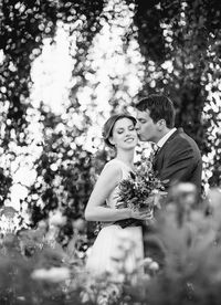 Bridegroom kissing bride at park