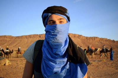 Portrait of man covered with scarf at desert