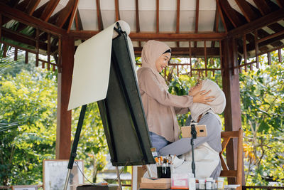 Side view of female friends embracing outdoors