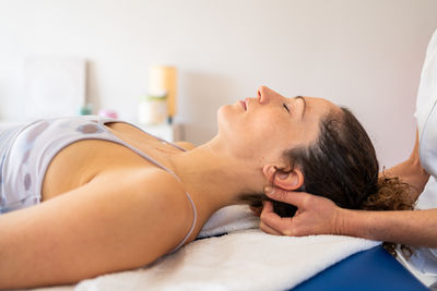 Close-up of woman lying on bed at home