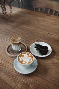 Latte art coffee on wooden table in coffee shop