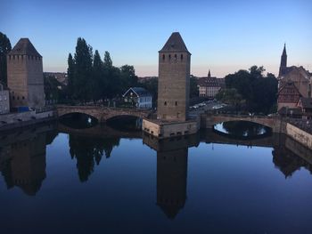 Arch bridge over river against sky in city