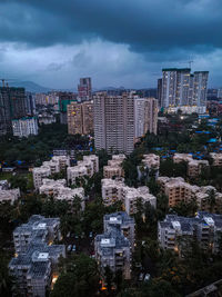 Modern buildings in city against sky at dusk