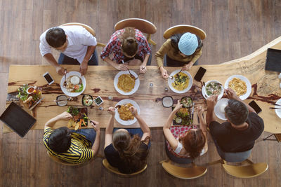 High angle view of people sitting on table