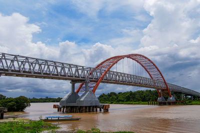 Arch bridge over river against sky