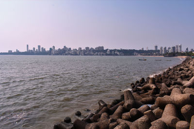 Scenic view of sea by buildings against clear sky