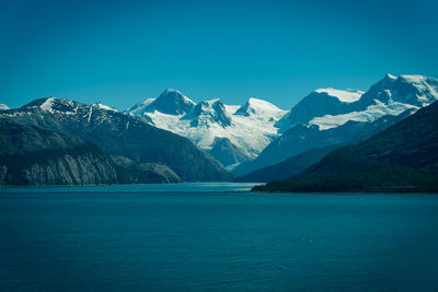 Scenic view of snowcapped mountains against blue sky