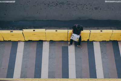 Rear view of woman standing on yellow umbrella