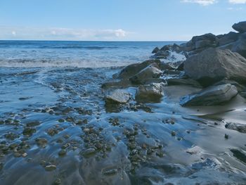 Rocks on beach against sky