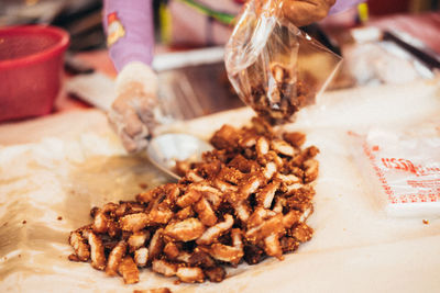 Midsection of person packing food at market stall