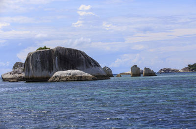 Rocks in sea against sky