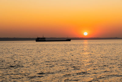 Scenic view of sea against orange sky during sunset