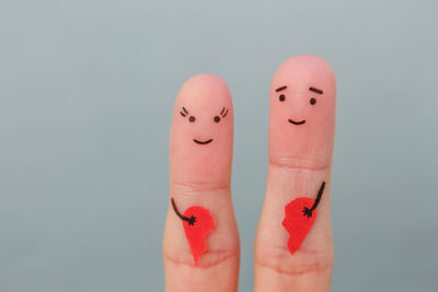 Close-up of human hand against colored background