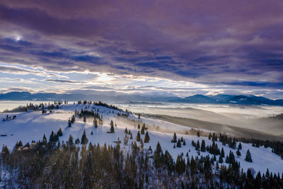 Scenic view of snowcapped mountains against sky during sunset