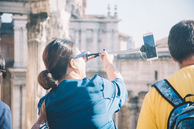 Rear view of woman photographing through camera