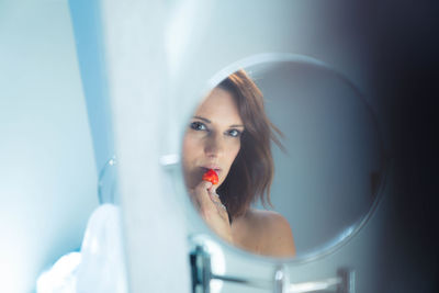 Portrait of woman with reflection in mirror