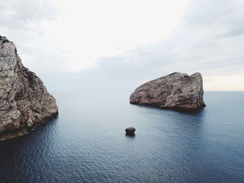 Rock formation in sea against sky