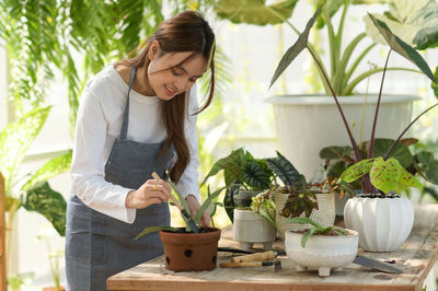 Young woman holding potted plant