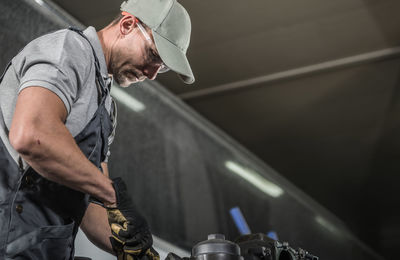 Man wearing cap working on garage