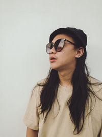 Young woman wearing sunglasses against white background