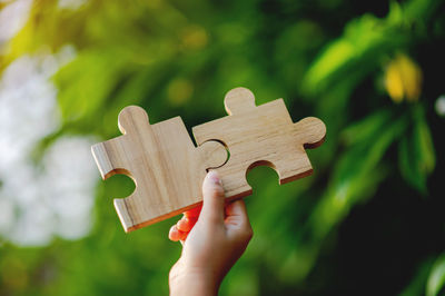 Cropped hand holding jigsaw pieces