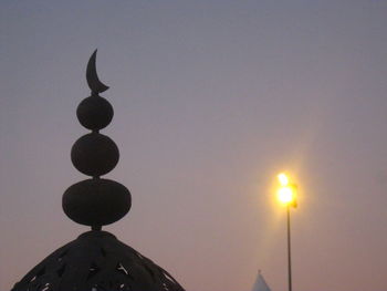 Low angle view of illuminated lamp against sky at dusk