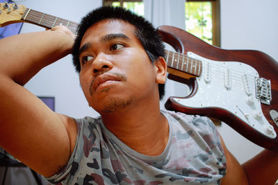 Portrait of young man playing guitar