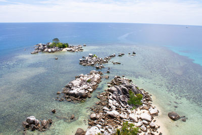 High angle view of rocks on beach against sky