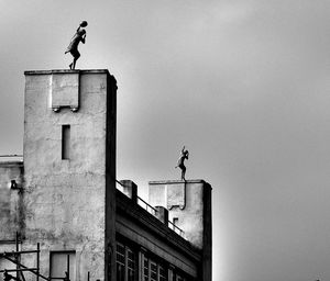 Statues and building against sky