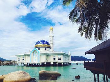 Mosque in lake against sky