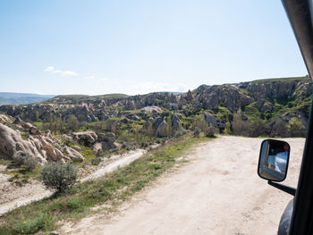 Road by mountains against sky