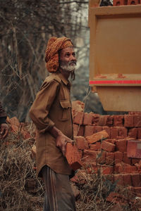 Midsection of old man  standing by plants during winter