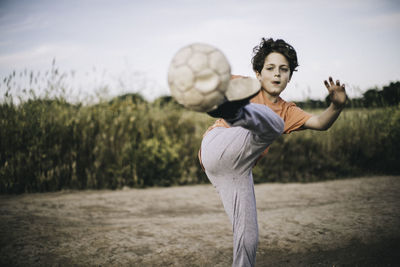 Boy playing soccer ball on field