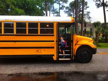 Student boarding school bus in city