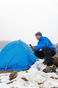 Rear view of man sitting on tent