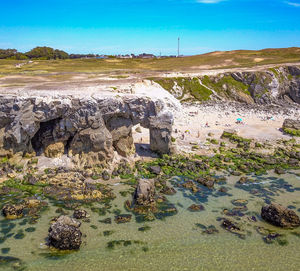 Scenic view of rocky shore against sky
