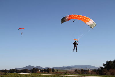 People paragliding against clear sky