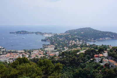 High angle view of town by sea against sky