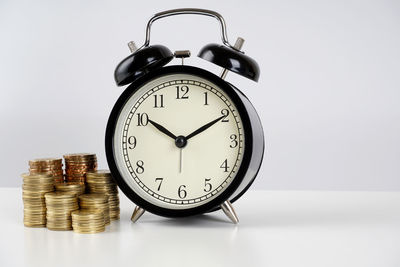 Close-up of clock on table against white background