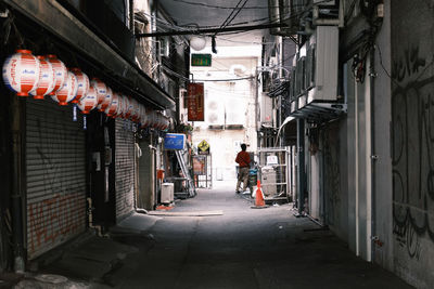 Rear view of people walking on street amidst buildings